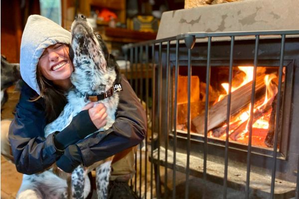 Dog enjoying indoor rest time with a handler during winter day camp at Camp Happy Paws